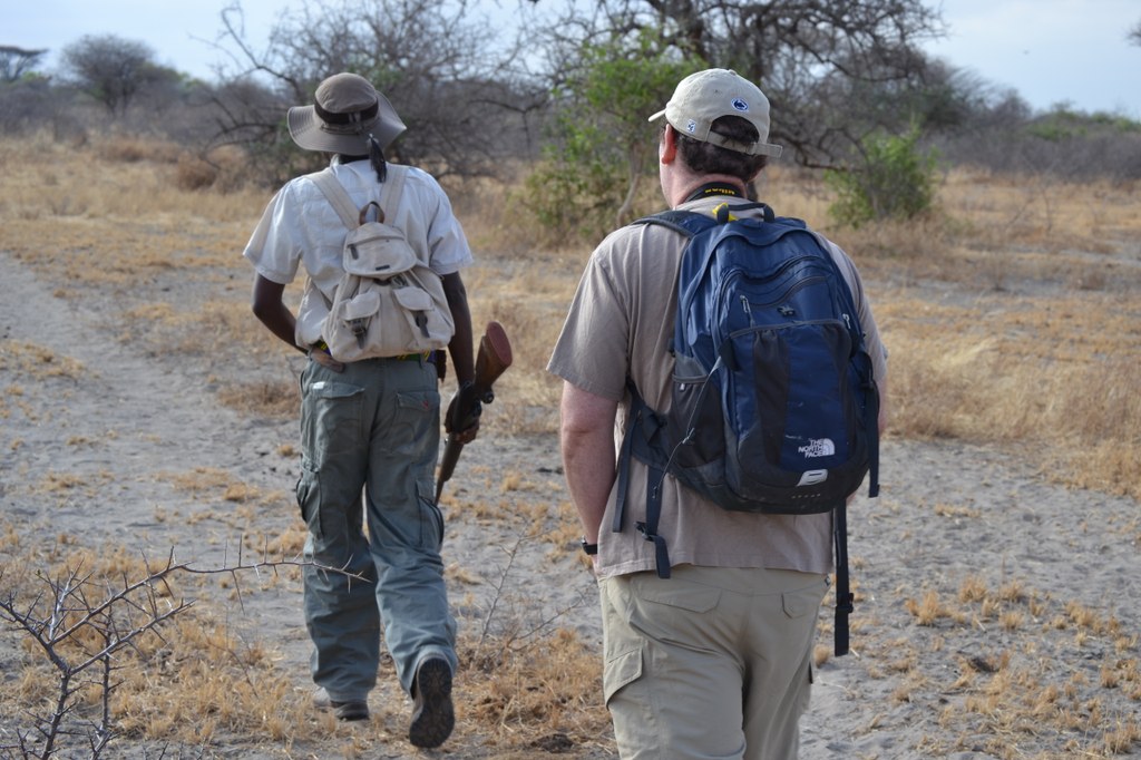 Our first walk.  Always in single file with no deviating from this order: the tracker in front with a rifle, Matt next, then I, and the park ranger with an AK-47 last. If anything serious happened (like an elephant charging), we were to go and stand (not run) with the park ranger while the tracker took care of the situation (whatever that would be??!!). Photo courtesy of Donald D. Davis.